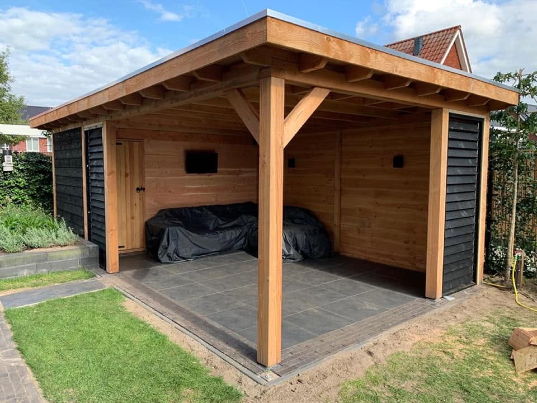 Houten overkapping met loungehoek en tegelvloer