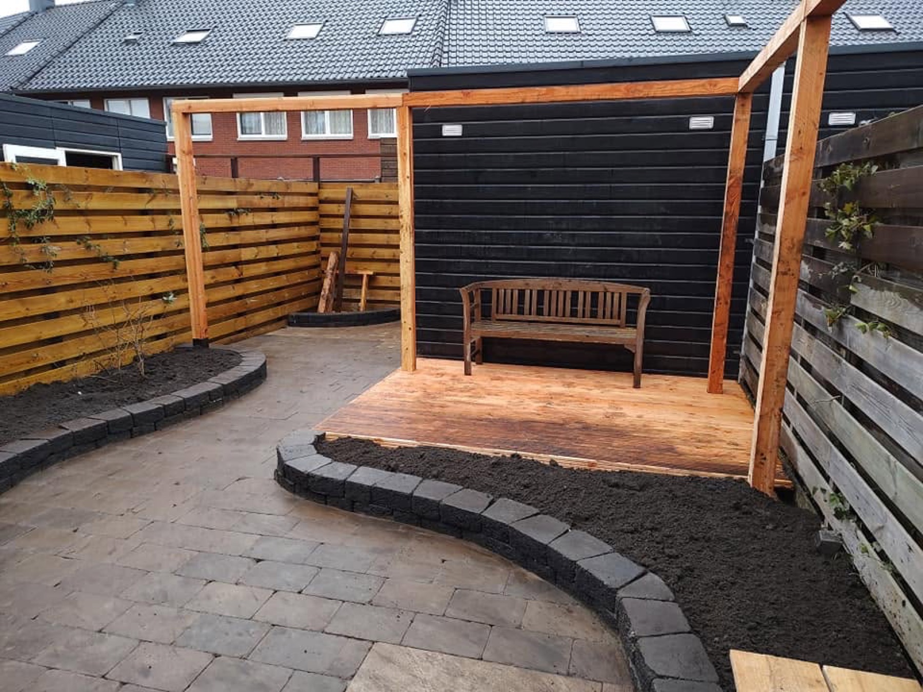 Compacte tuin met pergola, bankje, bestrating en borders